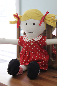 Blonde doll wearing a red + white polka dot dress featured in the Make a Friend Doll's Wardrobe Sewing Pattern by Jennifer Jangles