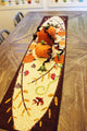A Walk in the Woods Fall Table Runner Applique Sewing Pattern by Jennifer Jangles displayed on a table with decorative fabric pumpkins